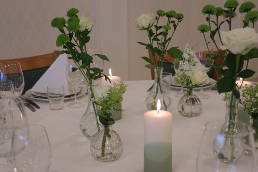 Bordpynt med grønne blomster og levende lys